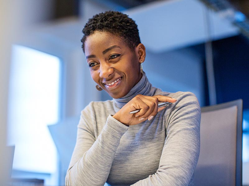 African American Woman Smiling With Pen In Hand