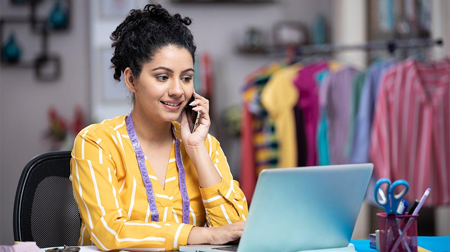 Young Female Seamstress Talking On Phone