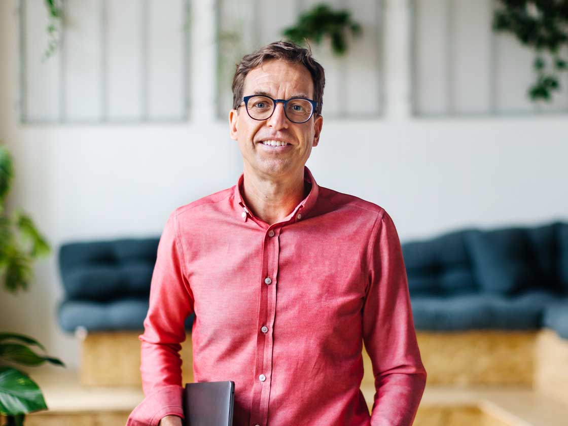 Man smiling at camera in an office lobby area