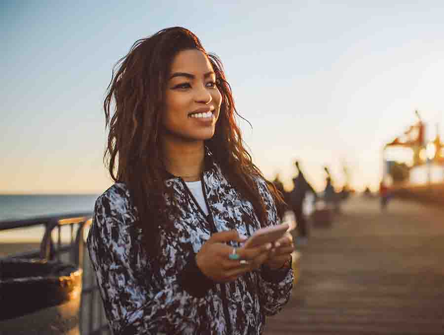 Young woman texting outdoors during sunset